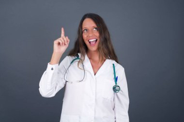 Tıp üniformalı çekici genç bir kadının yakından çekilmiş portresi bir parmağıyla yukarı bakıp gülümsüyor, bir fikrim var, cevabı ya da çözümü biliyorum..