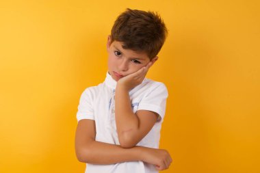 Yakışıklı çocuk sarı duvara karşı üzgün.  