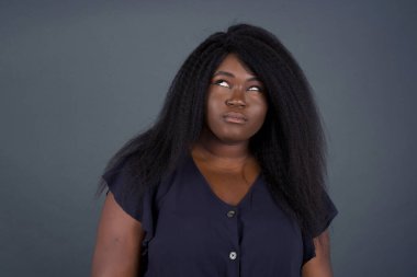 Hüzünlü, genç Afrikalı Amerikalı bir kadının dudaklarının arasından bakması, önemli bir şeyi düşünmesi, ellerini indirmesine engel oluyor.