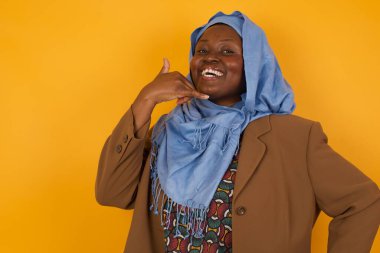 Çekici Afro-Amerikalı, gündelik giysiler içindeki Müslüman kadın telefon konuşmasını taklit ediyor, cep telefonu tutar gibi kulağına yakın duruyor, kendine güveni tam bir yüz ifadesi var. Ara beni.!