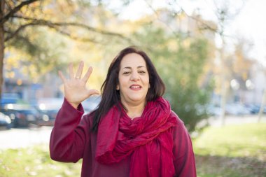 Parkta elini gösteren orta yaşlı güzel bir Arap kadın.  