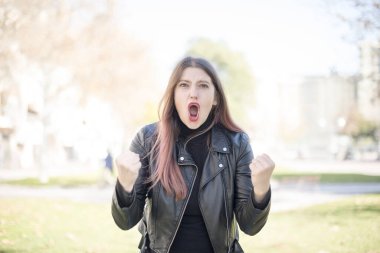 Genç ve güzel bir kadın parkta bağırıyor.  