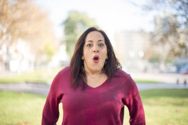 Güzel orta yaşlı bir Arap kadının parkta kafası karışıyor.  