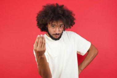 Kızıl duvarda saçları olan genç adam işaret ediyor.  