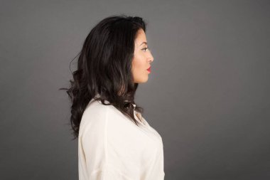 Güzel esmer kadın manzarası. Gri arkaplanda duruyor. 