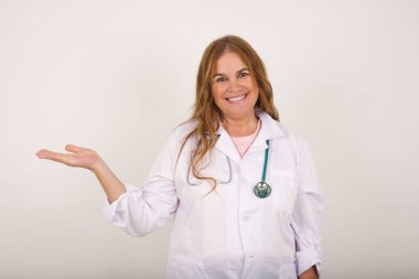 Pozitif memnun doktor diyor ki: Vay be, ne kadar heyecan verici, hayret verici bir ifade, boş alanda bir şey gösteriyor, açık elle izole edilmiş gri arkaplan üzerinde. Reklam kavramı.