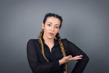 Boş uzayda elini açık tutarak izole edilmiş gri arka planda bir şey gösterdiğine seviniyorum. Reklam kavramı.