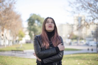 Genç ve güzel bir kadın parka bakıyor.