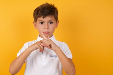 Sarı duvara yaslanan sevimli çocuk.  