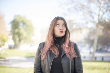 Genç ve güzel bir kadın parka bakıyor. 