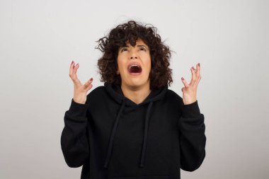 Çığlık, nefret, öfke. Mavi stüdyo arka planında ağlayan duygusal sinirli kadın..