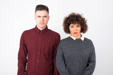  Sıradan kıyafetler giyen, kaşlarını çatan bir çift bir şeyden rahatsız oluyor..