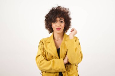 Neşeli, güzel bir genç bayanın, gri duvarın karşısında, yüzünün yanında durduğunu hayal et. İyi haberleri dinledikten sonra kameraya mutlu bir ifadeyle bakmak. Kendine güvenen kız..