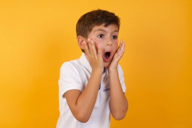 Yakışıklı çocuğun sarı duvara karşı kafası karışık.  