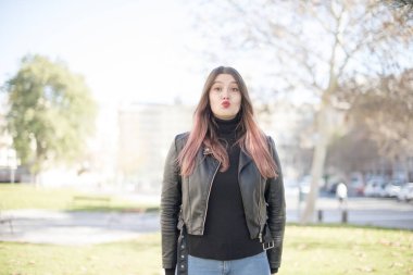 Genç ve güzel bir kadın parkta öpüşüyor. 