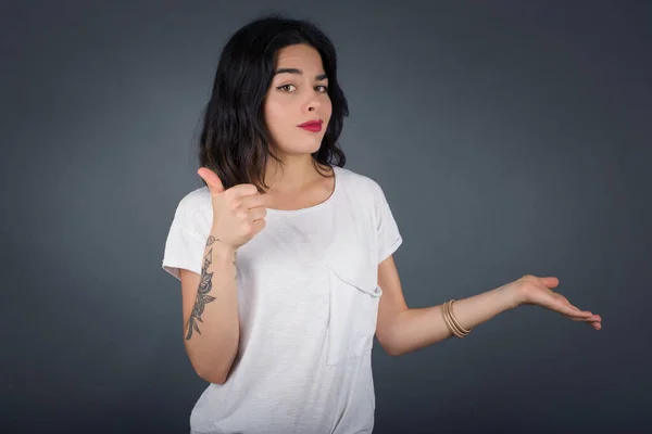 Young Happy Cheerful Woman Showing Thumb Pointing Other Hand While — Stock Photo, Image