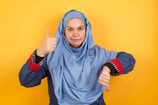 Güzel Orta Yaşlı Tesettürlü Müslüman Kadın Iyiye Kötüye Işaret Yapıyor — Stok fotoğraf