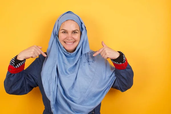 你找对人了 选我吧有自信 有魅力的中年穆斯林女子 头戴头巾 大张旗鼓地宣传自己缺少的角色 面带微笑 直指身体 — 图库照片