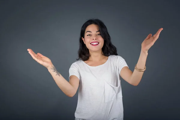 Cheerful woman making a welcome gesture raising arms over head isolated on white background.