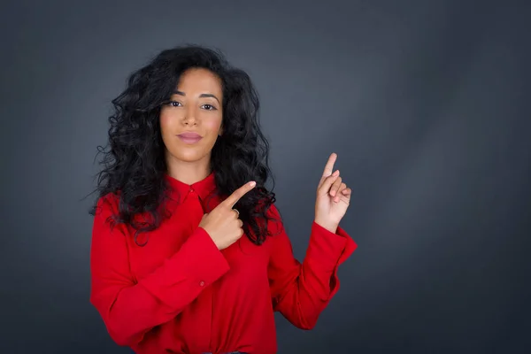 Kıvırcık Saçlı Kırmızı Tişörtlü Pozitif Esmer Kadın Işaret Parmağıyla Işaret — Stok fotoğraf