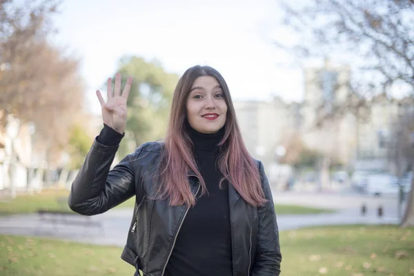 Parkta Dört Parmağını Gösteren Genç Güzel Bir Kadın — Stok fotoğraf