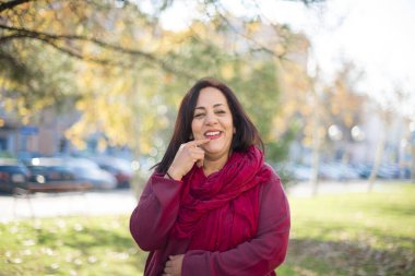 Parkta gülümseyen orta yaşlı güzel bir Arap kadın.  