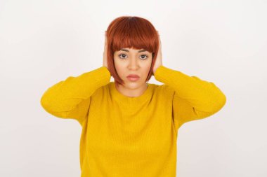 Duygusallıktan boğulan, kulaklarını tıkayan genç sevimli bir öğrencinin portresi. 