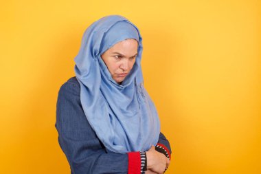 Closeup portrait displeased pissed off middle aged muslim woman in hijab   with bad attitude, arms crossed looking sideways. Negative human emotion facial expression feelings