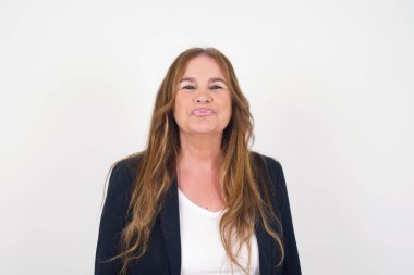 Hoş görünümlü orta yaşlı bir kadın, dudaklarını öpecek gibi tutuyor, mutlu bir ifadesi var, suratını buruşturmuş. Dışarıda dikiliyorum. Güzellik konsepti.