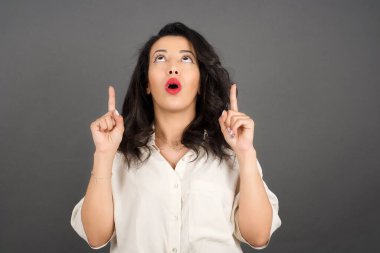 Gri arka planda gelişigüzel giyinmiş güzel esmer kadın..  