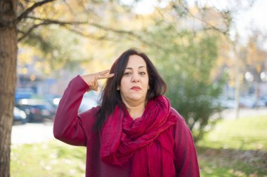 Parkta silahlı, orta yaşlı, güzel bir Arap kadın.  