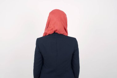 Güzel Müslüman kadının arkası siyah ceket ve tesettür giyer ve gri duvara dayanır. Stüdyo Çekimi.