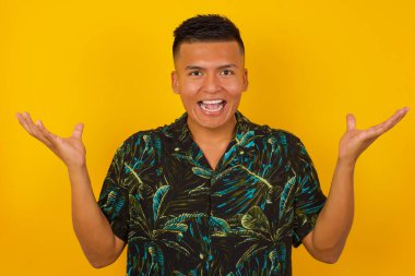 Neşeli genç erkek ellerini kaldırıyor, mutlulukla dolu gözleriyle büyük başarılarını kutluyor..