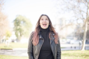 Genç ve güzel bir kadın parka bakıyor.