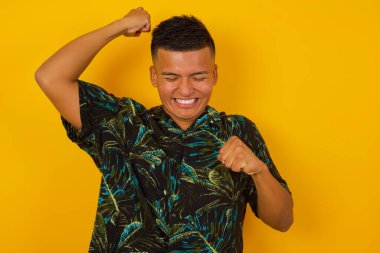 Çekici, genç İspanyol bir adam zaferi kutluyor yumruklarıyla havaya yumruk atıyor ve stüdyo arka planında fotokopi çekerek dişlek bir gülümseme yayıyor.