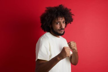 Kızıl duvara karşı afro saçlı genç adam.   