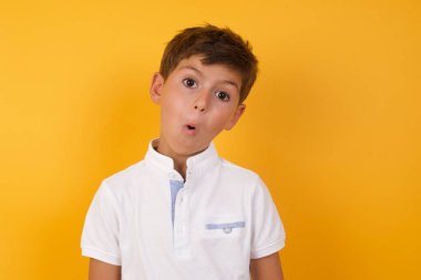 Yakışıklı çocuğun sarı duvara karşı kafası karışık.  