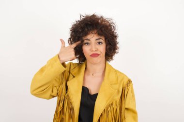 Süet ceketli güzel bir kadın stüdyo çekimlerini gösteriyor.