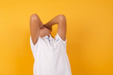 Yüzü sarı duvara dönük yakışıklı çocuk.  