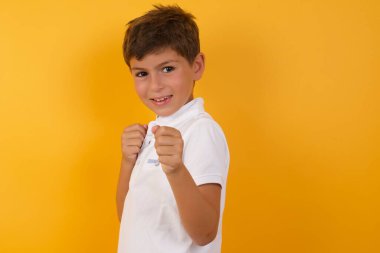 Yakışıklı çocuk sarı duvara karşı boks yapıyor.  