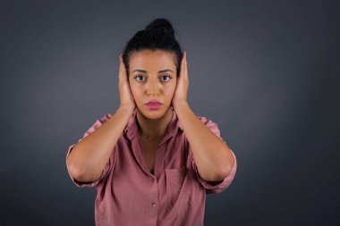 Elleriyle kulaklarını tıkayan kadın hard rock veya yüksek sesle müzik dinlemek istemiyor.