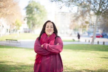 Parkta kollarını kavuşturmuş orta yaşlı güzel bir Arap kadın.  