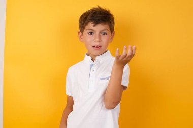 Yakışıklı çocuğun sarı duvara karşı kafası karışık.  