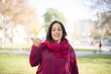 Güzel orta yaşlı Arap kadın parkı işaret ediyor.  