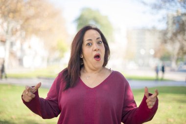 Güzel orta yaşlı bir Arap kadının parkta kafası karışıyor.  