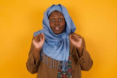 İnsan yüzü ifadeleri ve duyguları. Genç, çaresiz, Afro-Amerikan Müslüman kadın portresi paniğe kapılmış görünüyor, ellerini yüzüne yakın tutuyor, ağzı sonuna kadar açık. Umutsuzluk ve şok içindeki bir kadın