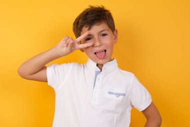 Sarı duvara yaslanan sevimli çocuk.  