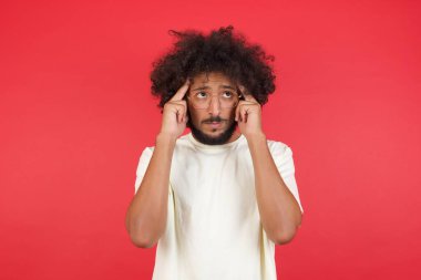 Kızıl duvarda başı ağrıyan afro saçlı genç adam. 
