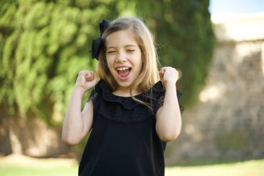 Güçlü ve kararlı genç bir bayanın belden aşağı portresi. Yumruklarını sıkma, sevinç ve heyecanla haykırma. Zafer, başarı ve başarı kavramı.