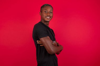 İçerde kolları bağlı duran neşeli, güzel, Afro-Amerikan bir adamın görüntüsü. Kameraya bakıp gülümsüyor. Kendinden emin çocuk..